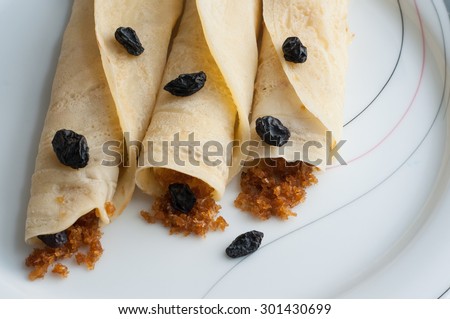pancakes, rolled filled with shredded coconut flakes miked with sweet. egg roll confectionery sweet snacks of Kerala India. tasty food made of rice or wheat rolled.