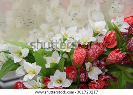 Closeup of beautiful white lilies flowers bouquet with water dew drops and rain background. decoration artificial white lily flowers reflected on glass window in a vase