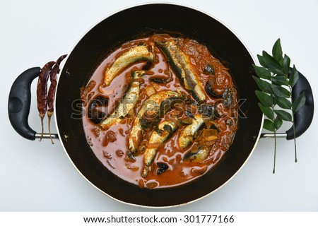 sardine fish cooked. Traditional hot and spicy fish curry Kerala India with dried red chilly and green curry leafs. Very popular coastal food eat with with tapioca or rice.