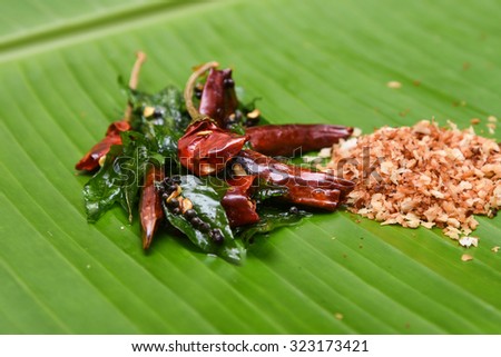 vattal mulaku, Kashmiri/Kashmiry, chili pepper/chile/chilli pepper on a banana leaf, genus Capsicum. Dry red chilly pepper, curry leaves for seasoning  sambar, chutney, curry. Kerala,Tamil Cusines
