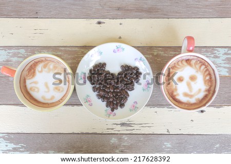 two of coffee cups with coffee bean make heart symbol