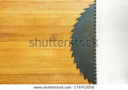 saw blade and wood saw on the background of wooden boards