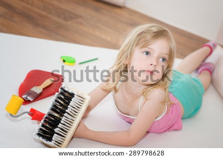 Little girl. Apartment repair. Wallpapering. Stock Photo