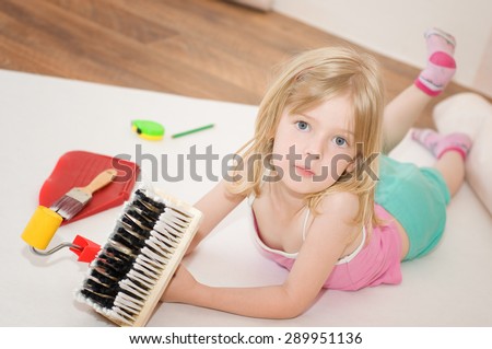 Little girl. Apartment repair. Wallpapering. Stock Photo