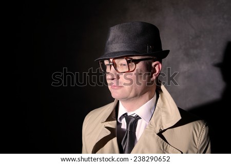 retro style business man with seventies horn-rimmed glasses and a trench coat