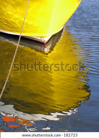 Reflection of yellow hulled boat moored at Whitby.
