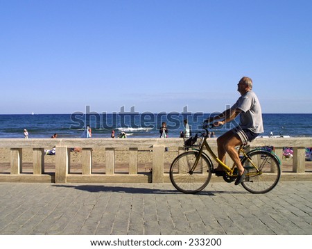 Man cycles on promenade. Diano Marina, Italy. Editorial use only.
