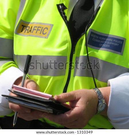 Close-up of community support police officer issuing parking tickets