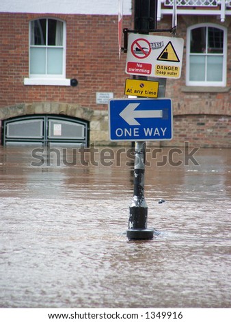 Warning signs on flooded River Ouse bank in York, UK.