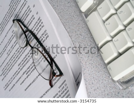Reading glasses rest on a health and safety report.