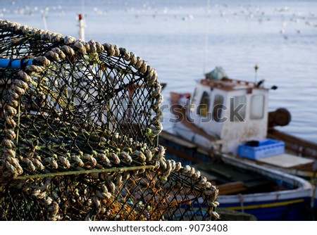 Stacked lobster baskets with out of focus fishing boats