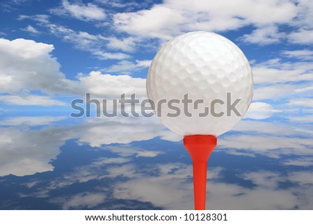 Golf ball on red tee with sky reflected on ground