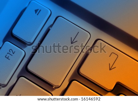 Close-up of computer arrow keys with blue and yellow lighting