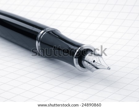 Close-up of fountain pen resting on graph paper