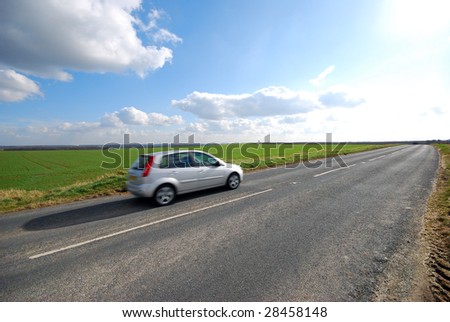 Car travels down Yorkshire country road in sunshine