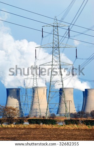 Telephoto view of coal power station cooling towers and electricity pylon