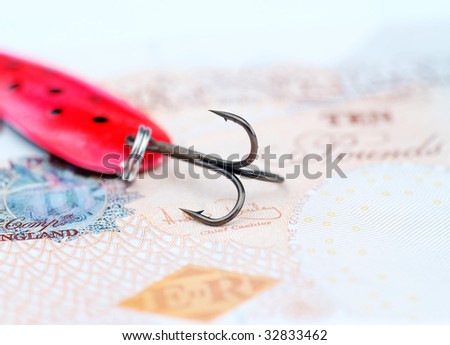 Close-up of fishing hook resting on UK bank note