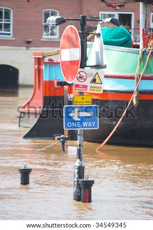 Flooded traffic signs on bank of River Ouse in York.