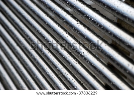 Rain drops cling to stainless steel tubes