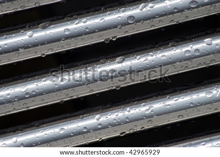 Rain drops cling to stainless steel tubes