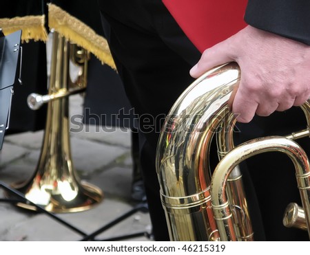 Man holds brass band instrument during street performance