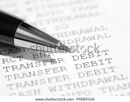 Closeup of pen resting on a bank statement