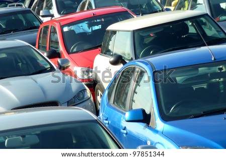 Telephoto view of cars parked in parking lot. Image can be reversed for non British uses. Useful for environmental issues.