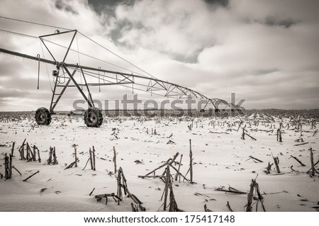 Glazed Farm Field with Irrigation Equipment After Winter Ice Storm, Snow and Frozen Rain