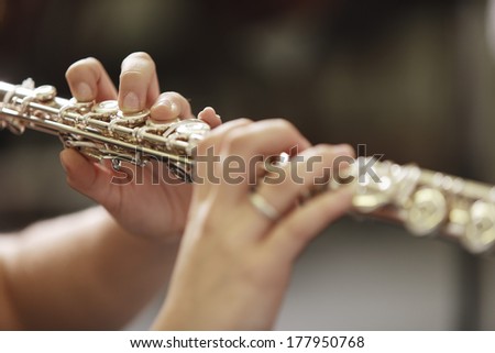 Hands of young woman playing the flute