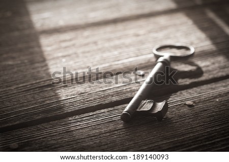 Rusty Old Skeleton Key on Dark Rustic Barnwood With Window Light