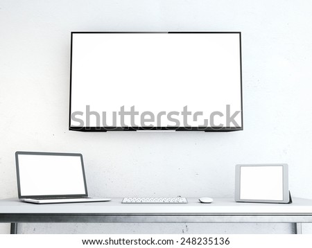 Table with laptop and large screen on the wall