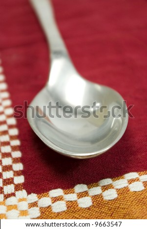 silver salad spoon on red square tablecloth
