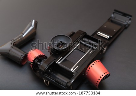 35mm analog reflex camera lying down on its roll film. With copy space