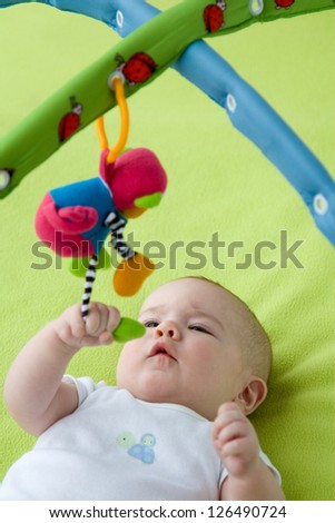 Baby grabbing a hanging down toy