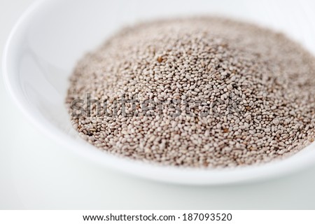 White chia seeds in a bowl against white background