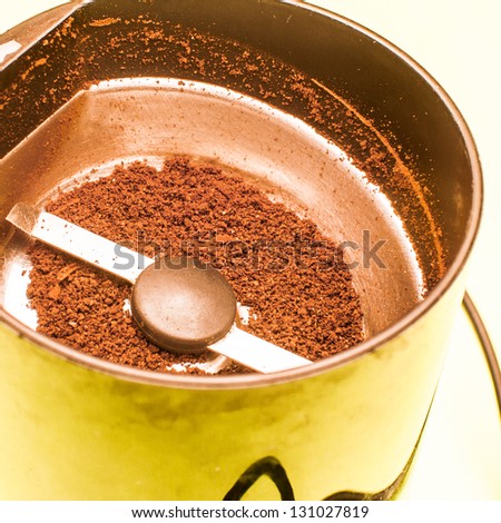 freshly ground coffee beans in an electric coffee grinder