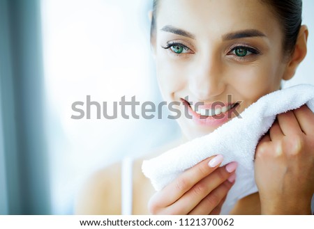 Health and Beauty. Beautiful Young Girl with White Teeth Holding a White Towel in Hands. A Woman With A Beautiful Smile. Tooth Health. Clean and Fresh Skin