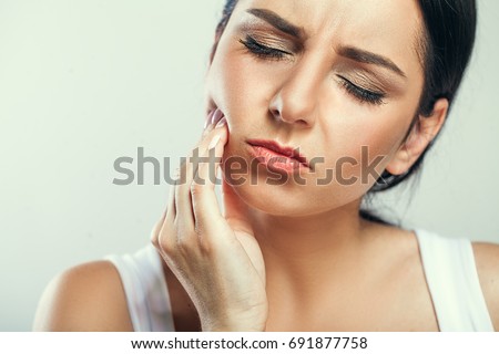 Tooth Pain And Dentistry. Beautiful Young Woman Suffering From Terrible Strong Teeth Pain, Touching Cheek With Hand. Female Feeling Painful Toothache. Dental Care And Health Concept. High Resolution