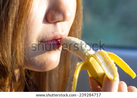 Young woman eating banana