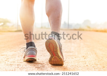 running sport feet on trail healthy lifestyle fitness.  sunset jogging workout wellness concept.