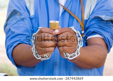 Dramatic detail of the chained with master key hands of an adult man on white background