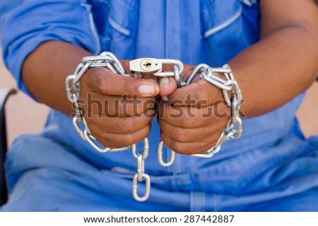 Dramatic detail of the chained with master key hands of an adult man on white background