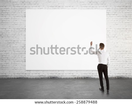 Businessman standing with back and writing on blank banner