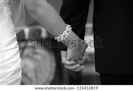 Bride and groom holding hands at the ceremony in the church