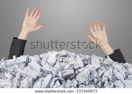 Hands reach out from big heap of crumpled papers