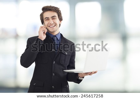 Portrait of young businessman holding laptop