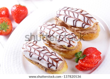Cream puffs with cream and strawberries, strawberry sauce.