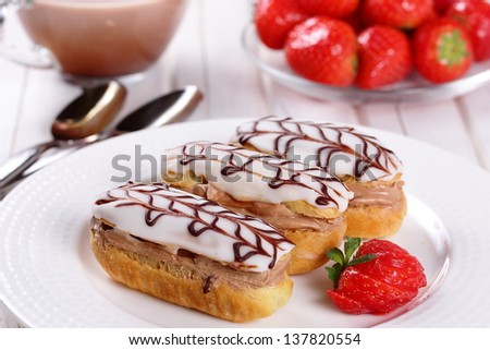 Cream puffs with cream and strawberries, strawberry sauce.
