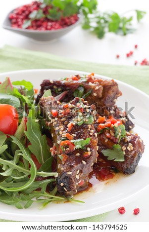 Pork ribs in ginger glaze with salad.