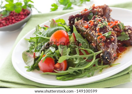 Pork ribs in ginger glaze with salad.
